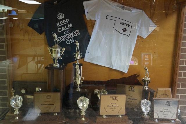 Trophy Case with Baseball Trophies. and Cougar T-shirts.