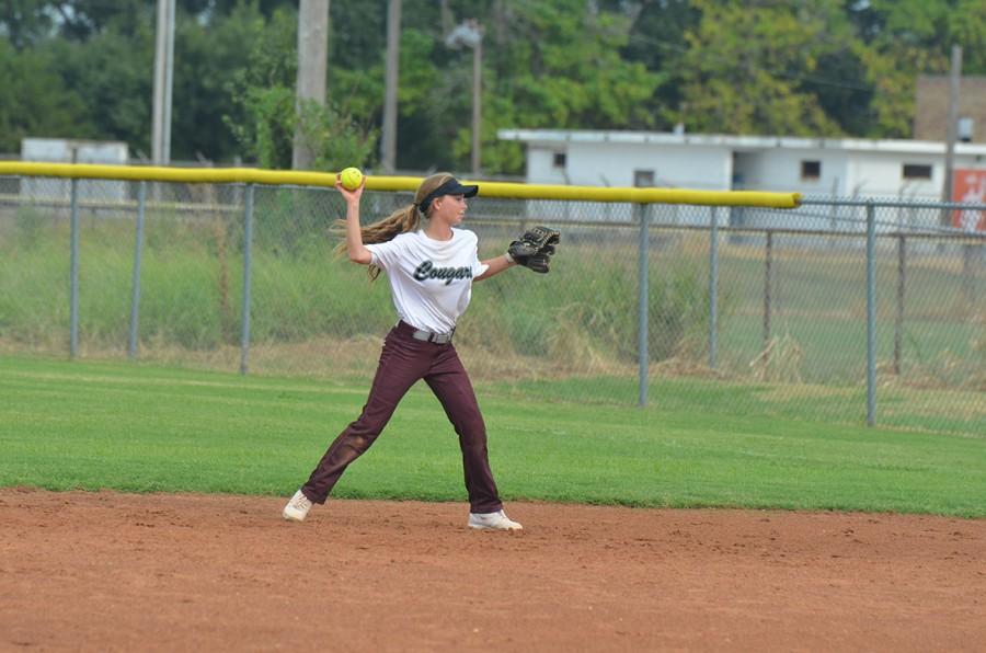 Number eleven, Katie Redman, tosses the ball to first base.
