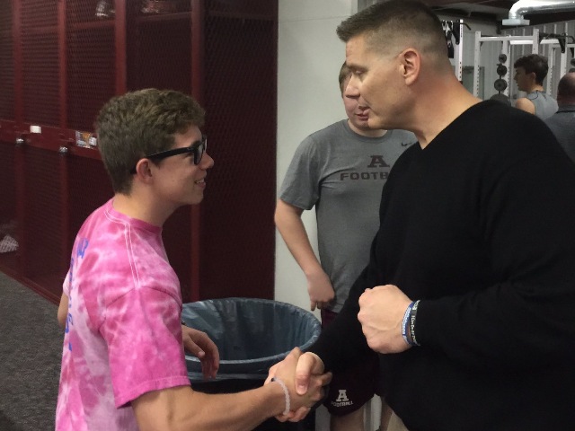 New Ada head football coach, Chris Berus, gets to know running back, Garrett Rhynes in Berus' first team meeting.