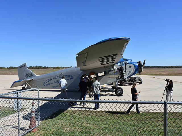 Awaiting take off, news reporters and volunteers marvel at the Ford Tri:Motor airplane. 