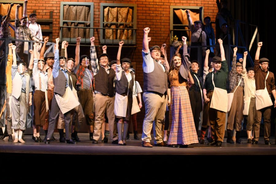 The cast of Newsies performs the finale of the show during the Newsies Square scene.